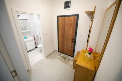a hallway with a bathroom with a wooden door at Apartman Mihalena in Banja Luka