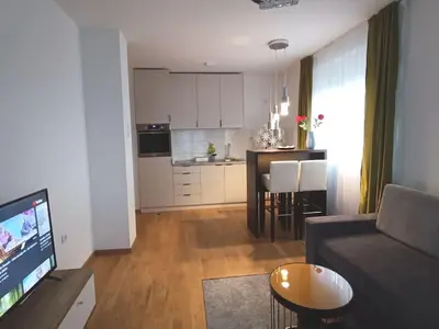 a living room with a couch and a table and a kitchen at Apartment Allora ,with garage in Banja Luka