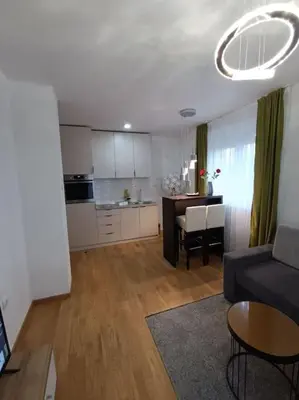 a living room and kitchen with a couch and a table at Apartment Allora ,with garage in Banja Luka