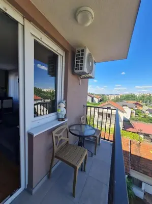 a balcony with a table and chairs and a window at Apartment Allora ,with garage in Banja Luka