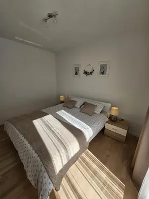 a bedroom with a bed and a night stand with two lamps at Apartman 33 in Kiseljak