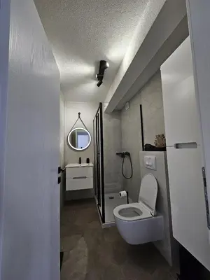 a bathroom with a toilet and a sink and a mirror at Apartman 33 in Kiseljak