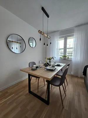 a dining room table with chairs and a mirror at Apartman 33 in Kiseljak