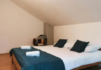 a bedroom with a large bed with black and white pillows at Apartman Oskar 1 in Kupres