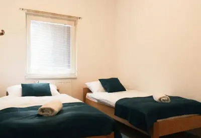 two beds in a room with a window at Apartman Oskar 1 in Kupres