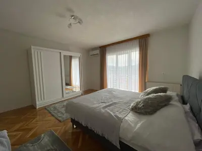 a bedroom with a bed and a large window at BORIĆI in Bihać