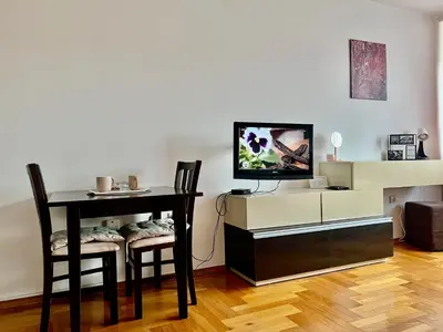 a living room with a table with two chairs and a tv at Apartman A&A in Banja Luka