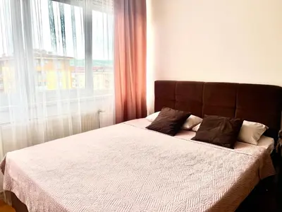 a bed in a bedroom with a large window at Apartman A&A in Banja Luka