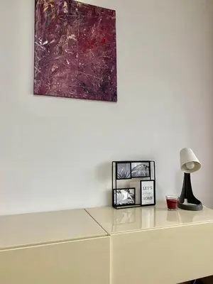 a table with a lamp and a painting on the wall at Apartman A&A in Banja Luka