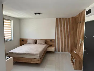 a bedroom with a bed with a wooden headboard at Apartmani Marković in Doboj