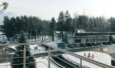 a street with snow on the ground and a building at Apartman Oskar 2 in Kupres