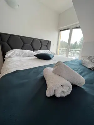 a bedroom with a bed with towels on it at Apartman Oskar 2 in Kupres