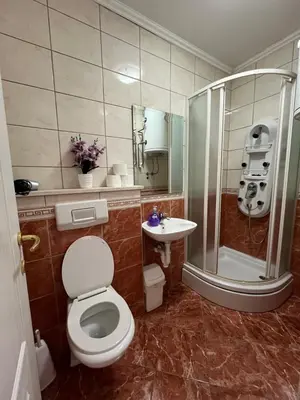 a bathroom with a toilet and a shower and a sink at Apartman Oskar 2 in Kupres