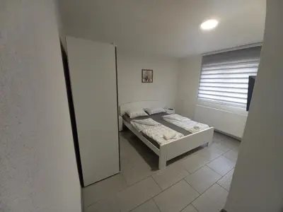 a small bedroom with a bed and a mirror at SOBE CICKO in Bosansko Petrovo Selo