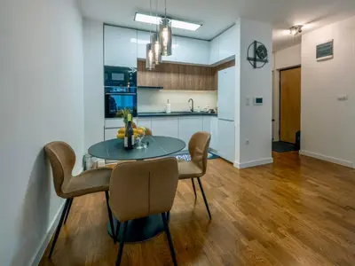 a kitchen and dining room with a table and chairs at Apartman K&S in Banja Luka