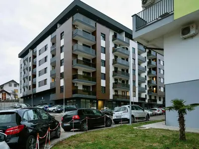a parking lot with cars parked in front of a building at Apartman K&S in Banja Luka