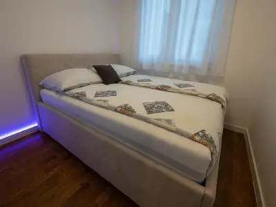 a bed in a small room with a window at Apartman K&S in Banja Luka