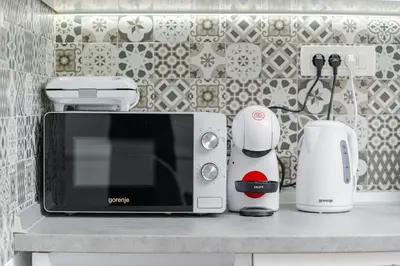 a kitchen counter with a microwave and other appliances on it at Mona Visoko in Visoko