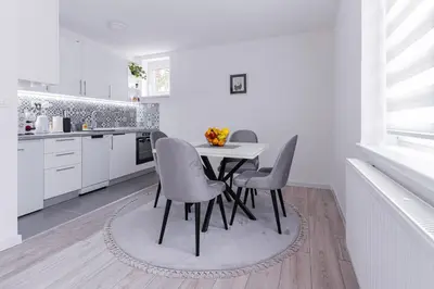 a white kitchen with a table and chairs at Mona Visoko in Visoko