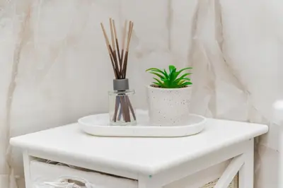 a white table with a plant in a vase on it at Mona Visoko in Visoko