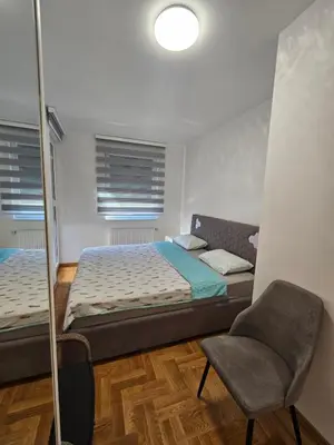 a bedroom with a bed and a chair and a mirror at Apartment Zidart Banja Luka free garage in Banja Luka