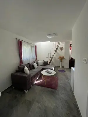 a living room with a couch and a table at Vikendica u prirodi na ranču in Zolaći