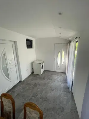 a white room with a tv and chairs in it at Vikendica u prirodi na ranču in Zolaći