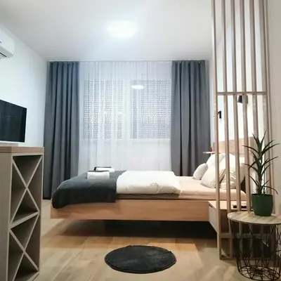 a bedroom with a large bed and a window at Apartman 33 in Banja Luka