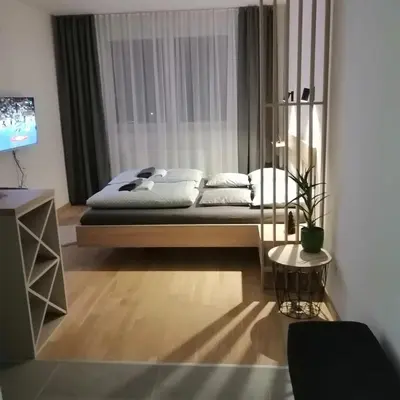 a bedroom with a bed and a table and a television at Apartman 33 in Banja Luka