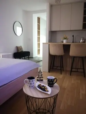 a room with a bed and a table with a plate of food at Apartman 33 in Banja Luka