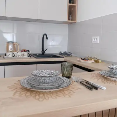 a kitchen with a table with plates on it at Apartman 33 in Banja Luka