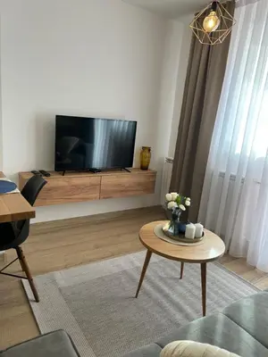 a living room with a tv and a coffee table at Apartman Mona in Teslić