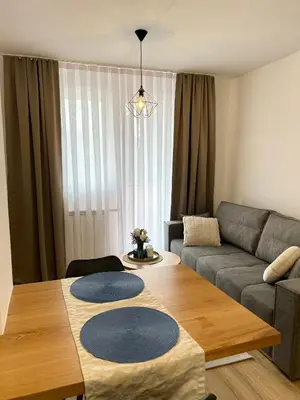 a living room with a table and a couch at Apartman Mona in Teslić