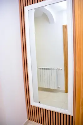 a mirror on a wooden wall in a bathroom at Apartman Mona in Teslić