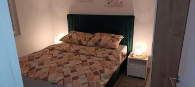 a small bedroom with a bed with a green headboard at Villa SHAMS in Travnik