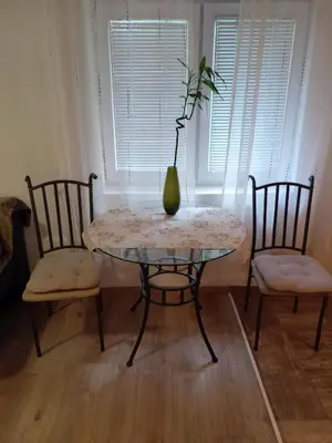 a table with a vase on it with two chairs at Apartman Babli in Banja Luka