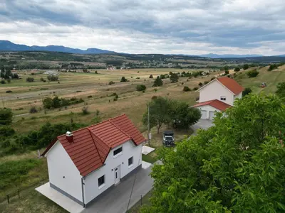 a white house with a red roof in a field at Fortuna in Livno