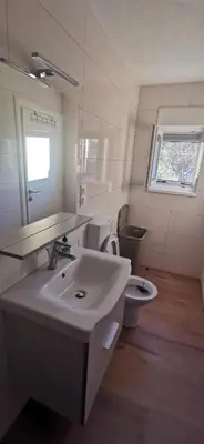 a white bathroom with a sink and a toilet at Fortuna in Livno