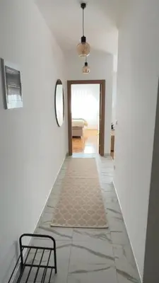 a hallway with a table and a chair in a room at ZARA Apartman Živinice in Živinice