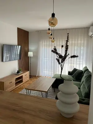 a living room with a green couch and a table at ZARA Apartman Živinice in Živinice