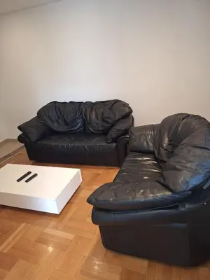 a black leather couch and a white box in a room at Luks 3 apartment in Banja Luka