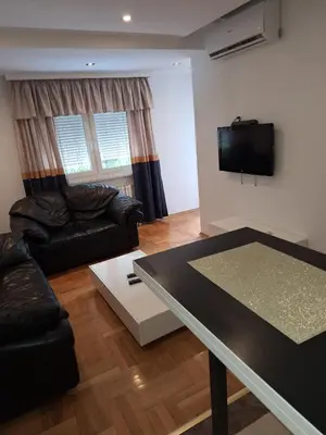 a living room with a table and a tv at Luks 3 apartment in Banja Luka