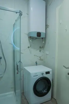 a washing machine in a bathroom with a glass door at Apartment ALPHA in Banja Luka