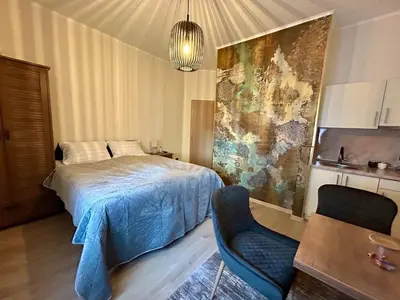 a bedroom with a bed and two chairs in it at AD BASANTE in Bosanski Šamac