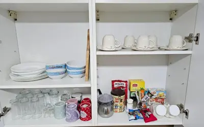 a cupboard filled with dishes and other items at Apartman 36 Banja Luka in Banja Luka