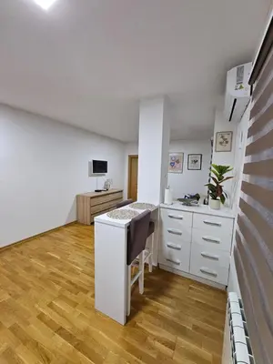 a white kitchen with a counter and a desk at Apartman 36 Banja Luka in Banja Luka