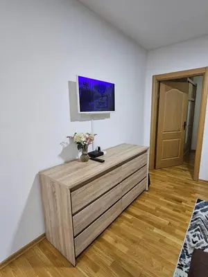 a room with a dresser with a tv on the wall at Apartman 36 Banja Luka in Banja Luka