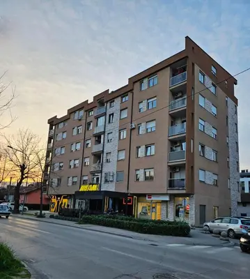 a large building on a street with cars parked in front at Apartman 36 Banja Luka in Banja Luka