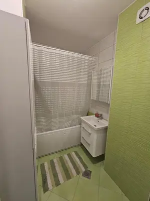 a small bathroom with a sink and a shower at Apartman 36 Banja Luka in Banja Luka