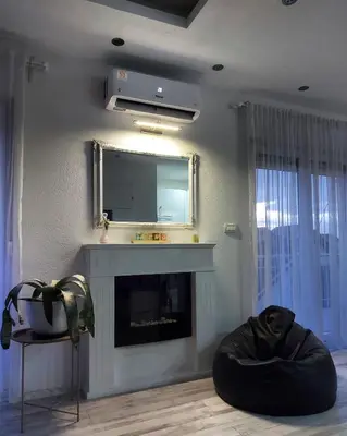 a living room with a fireplace and a mirror at Apartman TT Stan na dan Trn Laktaši in Laktaši